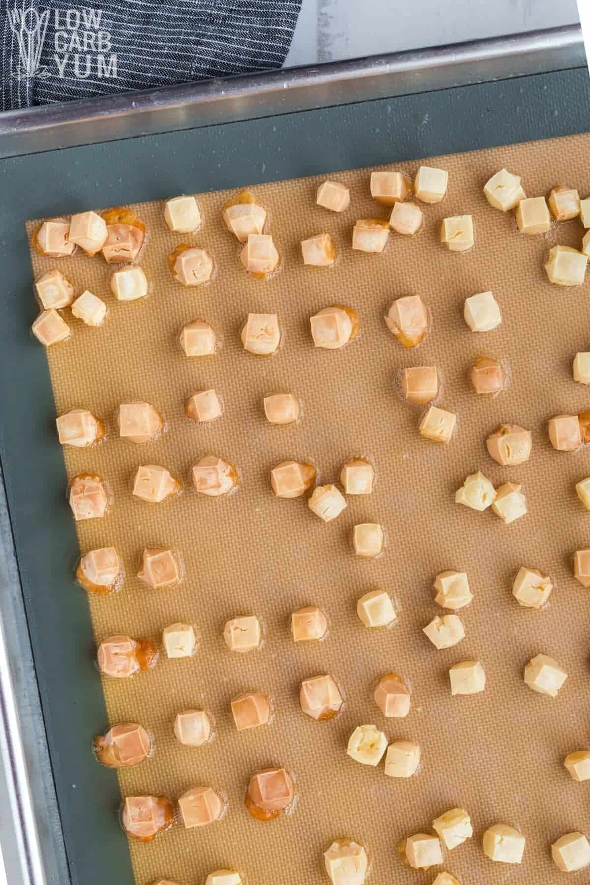 baked cheese cubes after baking on lined sheet pan