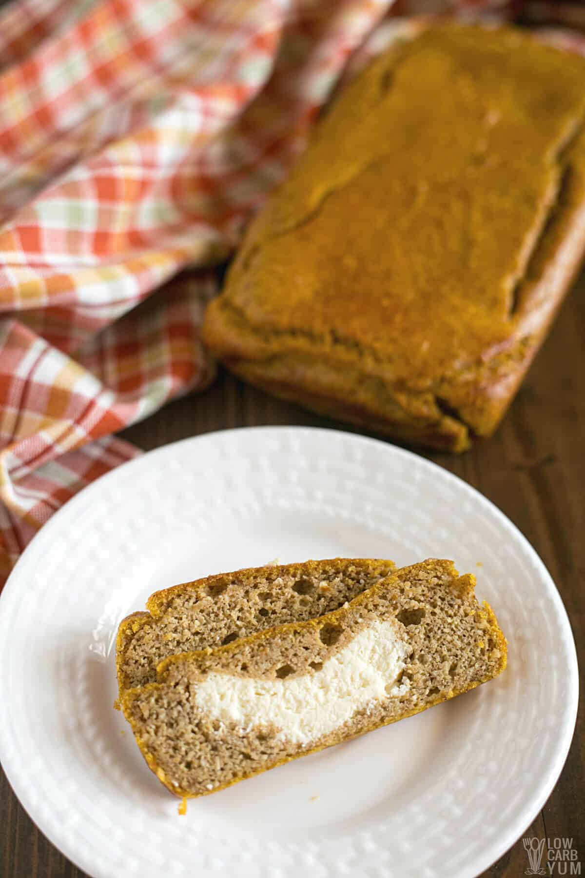 slices of cream cheese filled pumpkin bread on white plate.